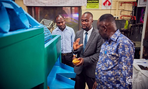 • Daniel Twumasi (middle) demonstrating the use of the cocoa pod-breaking machine