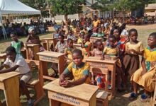 • Pupils happily seated on some of the donated desks