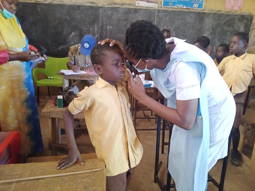 • A health worker screening a child