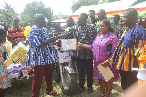 • Mr Nyarni (third from right) presenting a certificate to a farmer