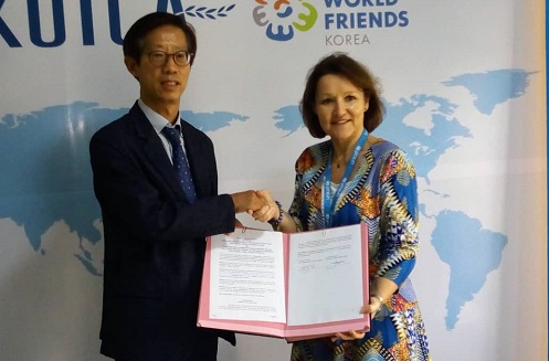 Ms Dufay (left) and Mr Kong in a handshake after the signing agreement
