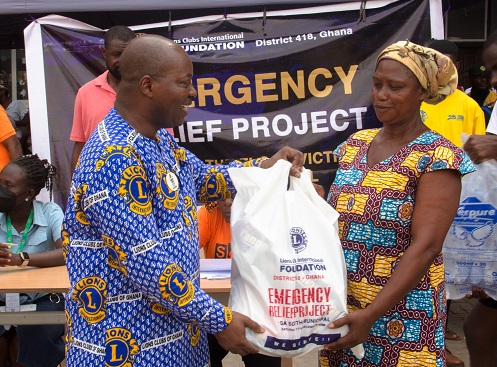 Mr Gyimah (left) presenting some of the relief items to a flood victim