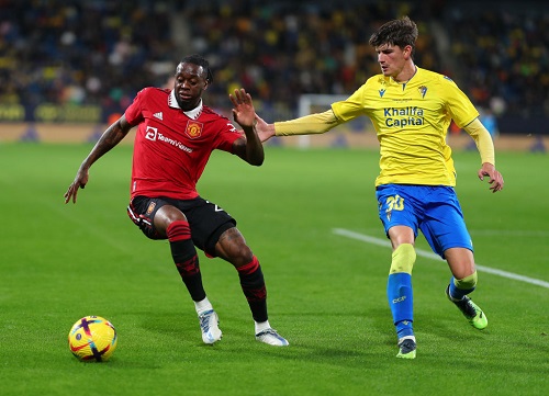 Wan Bissaka (left) has the upperhand in this tussle with a Cadiz player