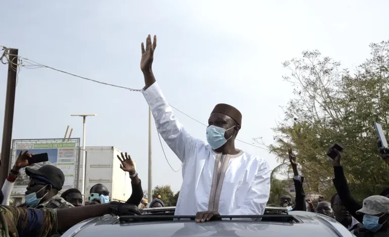 • Senegal's opposition leader, Ousmane Sonko, greets supporters as he passes by on his way to court in Dakar, Senegal