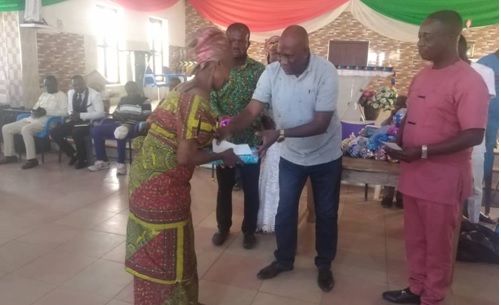 Mr. Ntim, middle, presenting a parcel to one of the widows.