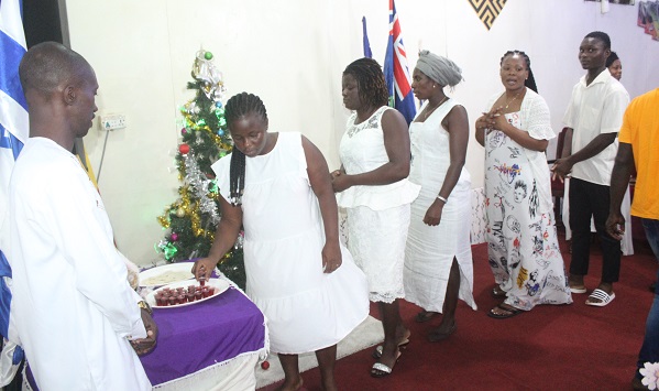 • Members of the Sanctuary of Grace Bible Church being served communion during the 31st watch night service Photo: Ebo Gorman