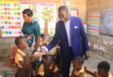 • Mohammed Bashiru Kamara presenting books to some pupils