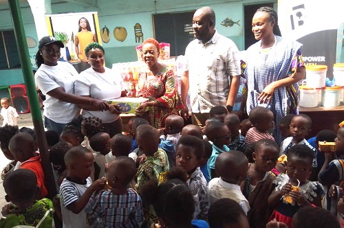 Ms Tekyi (second left) handing the donation to Mrs Engmann while the children and others look on