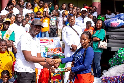 Miss Thompson (right) receiving the items from Mr Obeng.