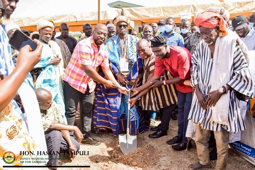 • Mr Tampuli (third from right) being assisted to cut the sod for the commencement of the project