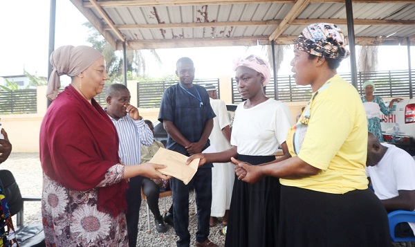 • Hajia Adam-Kuta (left) presenting a cash donation to one of the beneficiaries