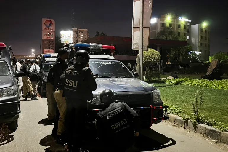 • Police officers take up positions after a police compound was attacked by gunmen in Karachi, Pakistan