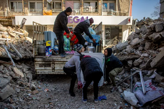 • Men recover some of their belongings from collapsed buildings in Hatay