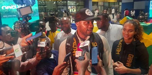 • Asafa Powell (in cap) and wife speaking to the media