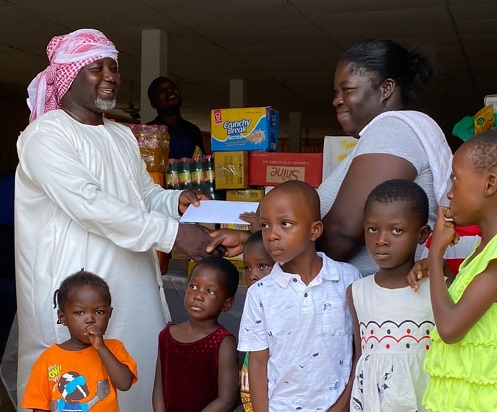 • Mr Ntiamoah (left) presenting the items to Ms Otemah, while the children look on