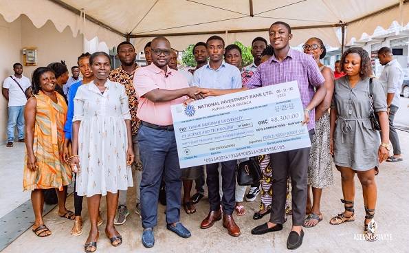Mr Asenso-Boakye (left) presenting the cheque to some beneficiaries