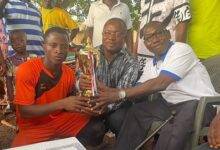 • Dumega Philip Mogan (right) assisted by Mr Dogba (centre) presenting captain of the Ghana team, Boukari Dakpo, with the trophy