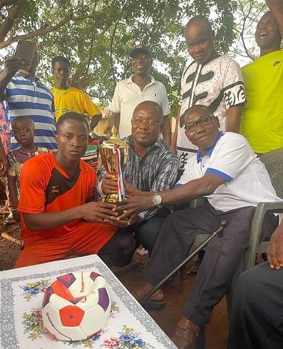 • Dumega Philip Mogan (right) assisted by Mr Dogba (centre) presenting captain of the Ghana team, Boukari Dakpo, with the trophy