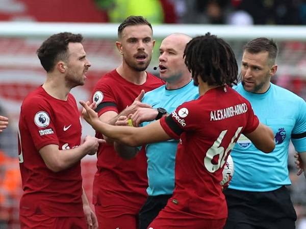 • Liverpool players surrounding referee Hooper during the game