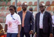 Madam Evelyn Nsiah Asare, an official of the Local Organising Committee leads Messrs Okraku and Belima (right) to the centre of the pitch