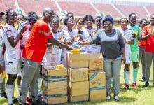 • Madam Oware-Mensah (right) presenting the items to Coach Basigi while the players look on