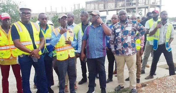 Inset; Mr Williams (left) with Mr Amoako- Atta and his team at the construction site