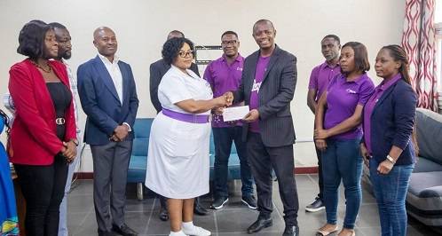 Mr Peter Kyei-Nimoh (third from right) handing over a cheque to an offical of the Korle-Bu Teaching Hospital