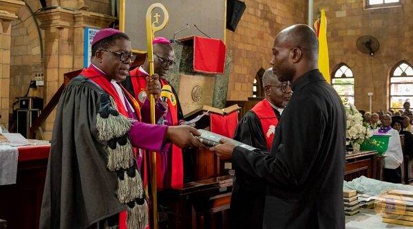 Most Rev. Boafo presenting a bible to one of the new Ministers