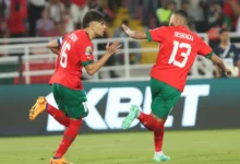 Morocco players celebrate the late win over Guinea in the opening match
