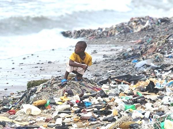 A child openly defaecating at a seashore in Tema Newtown, Accra