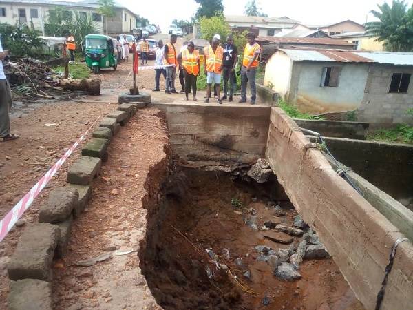• Ms Ivy Amewugah (left) with Mr Richard Bosson (right) and others inspecting a damaged bridge at Aleke