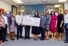 Ms Amuah (middle) presenting the dummy cheque to UNFPA Ghana