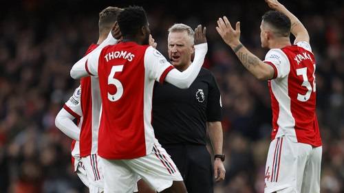 Arsenal players confronting a referee