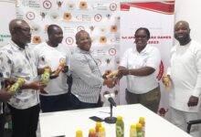 • Madam Roseline Acheampong (second right) presenting the drinks to Mr Boadi-Mensah