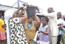 Ms Sowah (left) helping a beneficiary to carry her items Photo Victor A. Buxton...