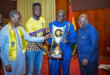 • President Akufo-Addo (right) receiving the trophy from Dr. Aubynn, Vincent Atinga, the skipper of the team and Mr Mireku Duker (left)