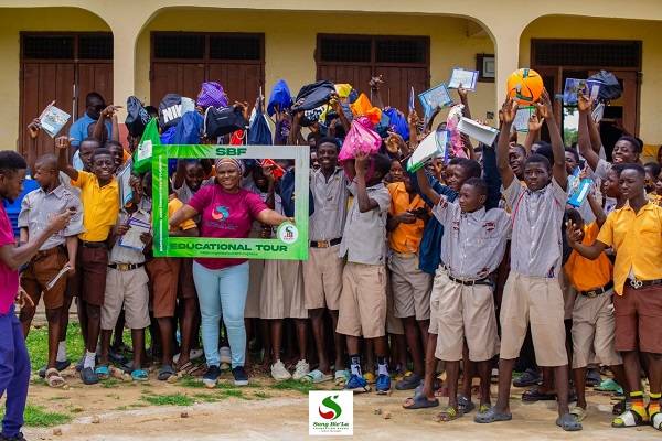Hajia Salifu with the beneficiary students as they display their items