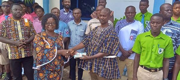 Okyeame Agyapong (in smock) hands over the cash to Mrs Babachoweh