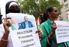 • Demonstrators hold placards and Niger flags as they gather outside the country's embassy in Paris in support of President Mohamed Bazoum