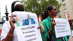 • Demonstrators hold placards and Niger flags as they gather outside the country's embassy in Paris in support of President Mohamed Bazoum