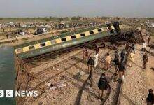 • Police officials inspect the carriages at the accident site following the derailment of the train