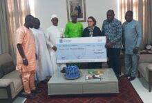 Officials of the fund presenting the dummy cheque to the Ambassador.