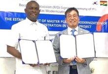 Dr John Ampontuah Kumah and Mr Dong Hyun Lee showing the signed MOU
