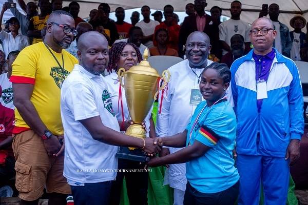 • Mr Addai-Danquah presenting the trophy to skipper of Palm Wine FC, Eugenia Korkor Tei. Looking is the MP for La Dadekotopon, Madam Rita Naa Odoley Sowah, former MP, Vincent Sowah Odotei (third right)