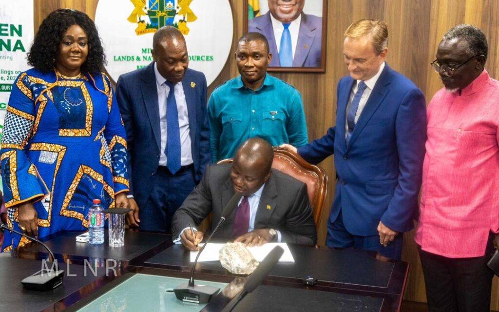 Mr Jinapor(seated) signing the document 