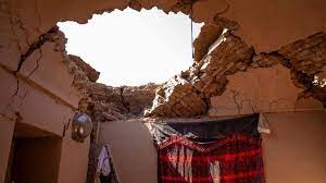 Cracked walls and a gaping hole in the ceiling of a house in Herat province