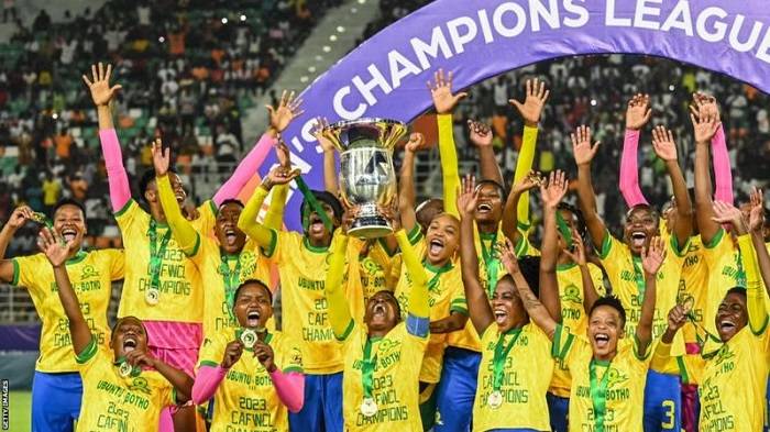• Sundowns players celebrating with the trophyria