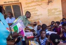 • Dr Eric Nkansah distributing gifts to the students during his visit
