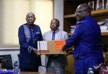 Dr Francis Kasolo presenting the medical supplies to Mr Agyeman-Manu (middle)