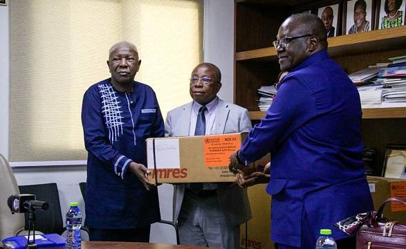 Dr Francis Kasolo presenting the medical supplies to Mr Agyeman-Manu (middle)